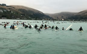 Hundreds of Christchurch surfers have paid tribute to the victims of last week's terror attacks with a paddle-out at Sumner Beach.