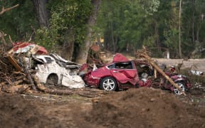 OLD FORT, NORTH CAROLINA - SEPTEMBER 30: Storm damaged cars sit along Mill Creek in the aftermath of Hurricane Helene on September 30, 2024 in Old Fort, North Carolina. According to reports, at least 90 people have been killed across the southeastern U.S., and millions are without power due to the storm, which made landfall as a Category 4 hurricane on Thursday. The White House has approved disaster declarations in North Carolina, Florida, South Carolina, Tennessee, Georgia, Virginia and Alabama, freeing up federal emergency management money and resources for those states.   Sean Rayford/Getty Images/AFP (Photo by Sean Rayford / GETTY IMAGES NORTH AMERICA / Getty Images via AFP)