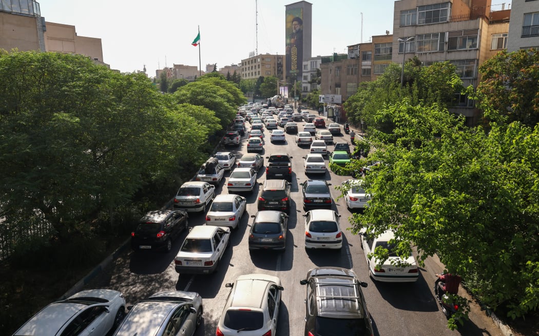Vehicles await in traffic as people get out of Tehran through an artery in the city's west on June 15, 2025. Iranian media said an Israeli strike hit the Tehran police headquarters in the city centre on June 15, as the two foes exchanged fire for a third day. (Photo by Atta KENARE / AFP)