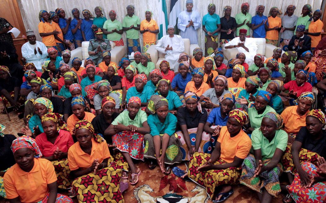 An handout picture released by the PGDBA&HND Mass Communication shows Nigeria's President Muhammadu Buhari (C) sitting among the 82 rescued Chibok girls during a reception ceremony at the Presidential Villa in Abuja, on May 7, 2017.