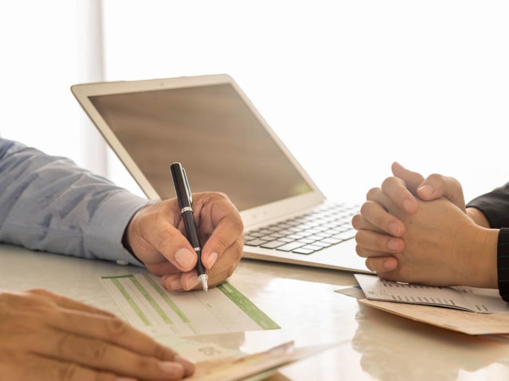 someone filling in a deposit slip in a bank