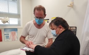 Minister of Health Andrew Little preparing to receive his flu vaccine.