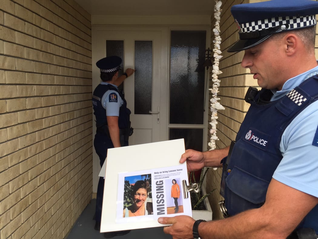 Police teams are going door-to-door in the Cable Bay and Taipa areas. Constable Kate Korach (knocking on the door) and Constable Marco Van Den Broek (holding the photo).