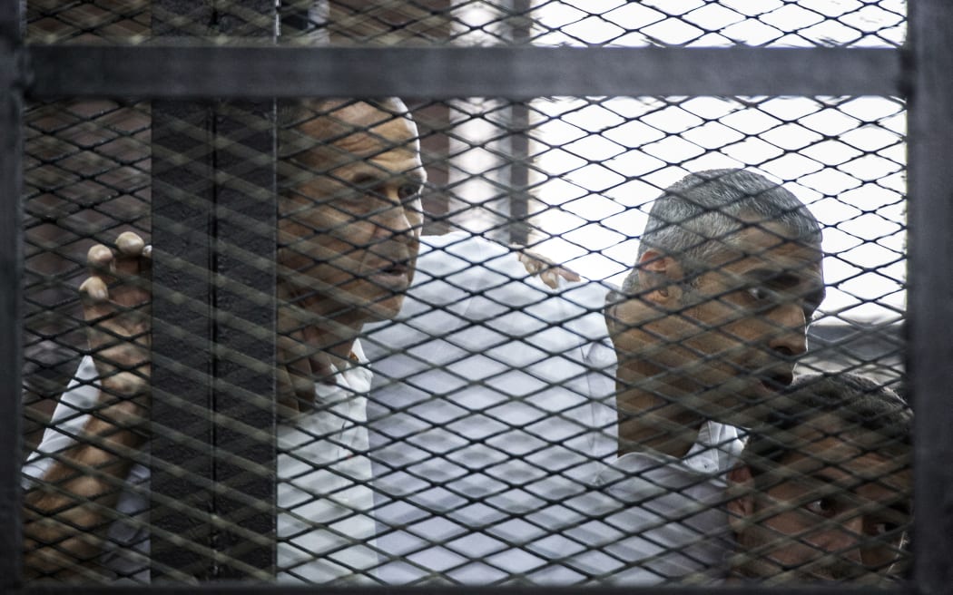 Peter Greste (left) Mohamed Fahmy and Baher Mohamed listen to the verdict.