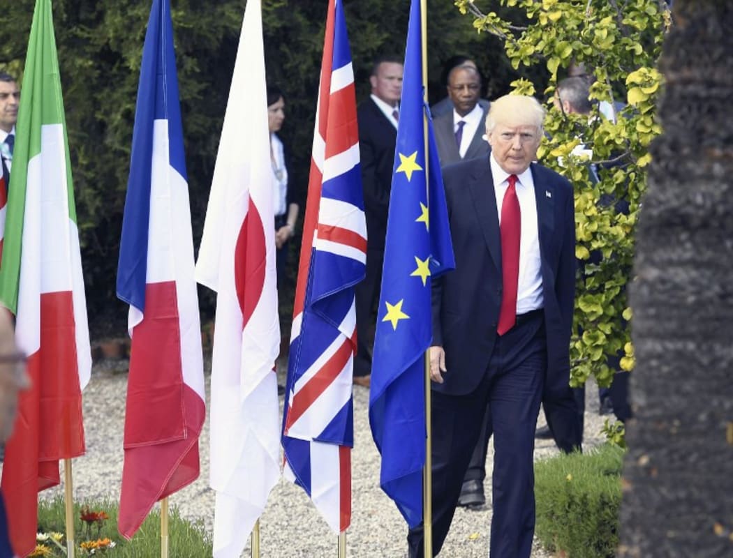 Donald Trump walks for a group photo after the Outreach Session during the G7 Summit.