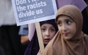 Children attend a vigil outside Finsbury Park Mosque in north London on June 20, 2017, following a van attack on pedestrians nearby on June 19.(Photo by Tolga AKMEN / AFP)
