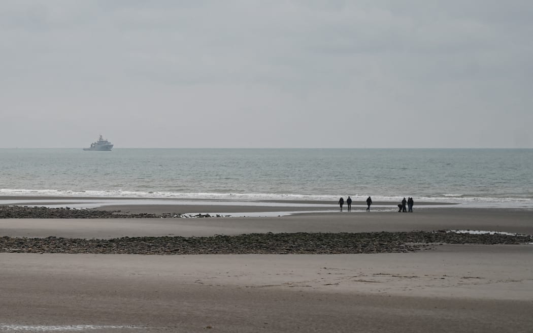 This photograph taken on January 14, 2024, on the beach of Wimereux, northern France, shows French military ship patrolling in the English Channel. Five migrants died on the night of 13 to 14 January 2024 near the beach of Wimereux (Pas-de-Calais) as they tried to reach a boat overboard in freezing water to cross the English Channel, the first fatal tragedy of 2024 off the French coast. (Photo by Bernard BARRON / AFP)