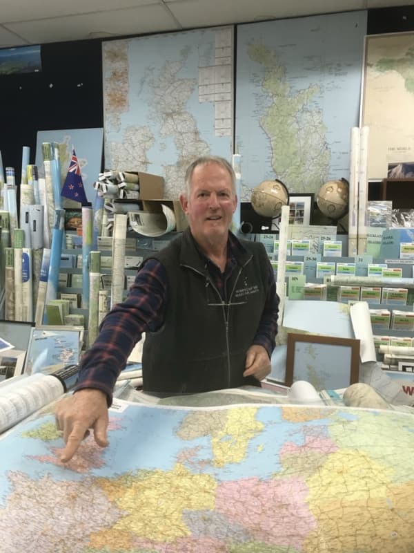 Owner of the Map and Chart shop, one of the few remaining specialist map shops in the country, Murray Jones pointing to one of the many maps in his shop.