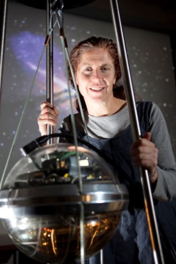 Jenni Adams with one of the IceCube optical sensors.