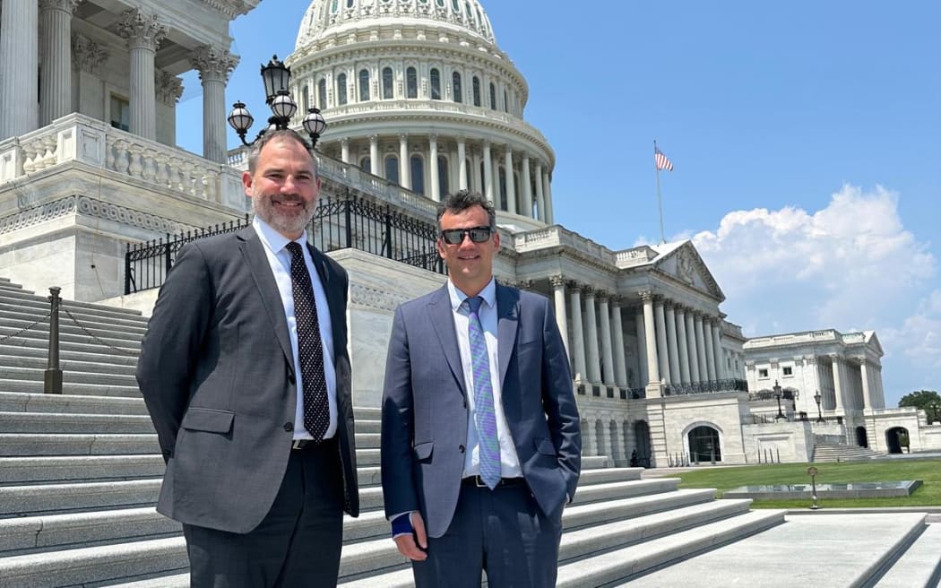 Two MPs pose for a photo in front of the Capitol building in Washington D.C.
