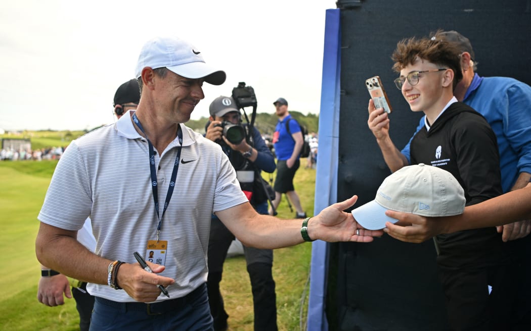 Northern Ireland's Rory McIlroy signs autographs for fans  during practice ahead of the 153rd Open Championship at Royal Portrush golf club in Northern Ireland on July 16, 2025. (Photo by ANDY BUCHANAN / AFP) / RESTRICTED TO EDITORIAL USE