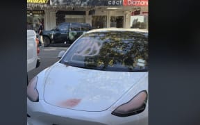 A photo of a Tesla marked with spray paint posted on Reddit with the caption 'Ouch, spotted on Ponsonby Road this morning.'