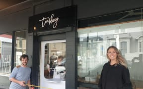 Tomboy cakery and café owner Kate Marinkovich tries out her new door which will her to to do contactless pickup.