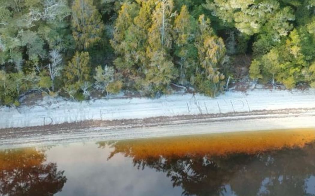A 'help' sign was written in the sand on the shore of Lake Ahaura on the West Coast.
