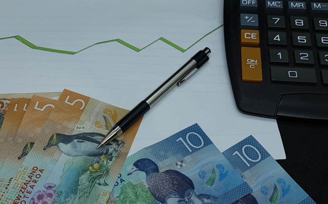 New Zealand banknotes, pen and calculator on background with rising trend green line