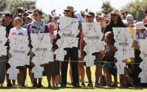 Kāhui (group) gathered at the Treaty grounds holding Toitū Te Tiriti posters as te hau kāinga prepare to welcome the government at Waitangi Monday 5 February 2024.