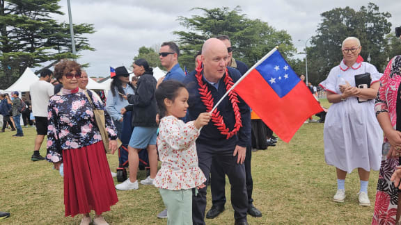 A girl shows her Samoan flag to Prime Minister Christopher Luxon, at the Auckland Pasifika Festival, Western Springs, on 9 March 2024.
