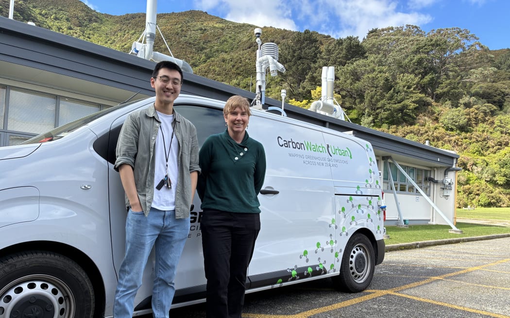 A man and a woman stand in front of a white van with the words 'Carbon Watch (Urban)' written on it.