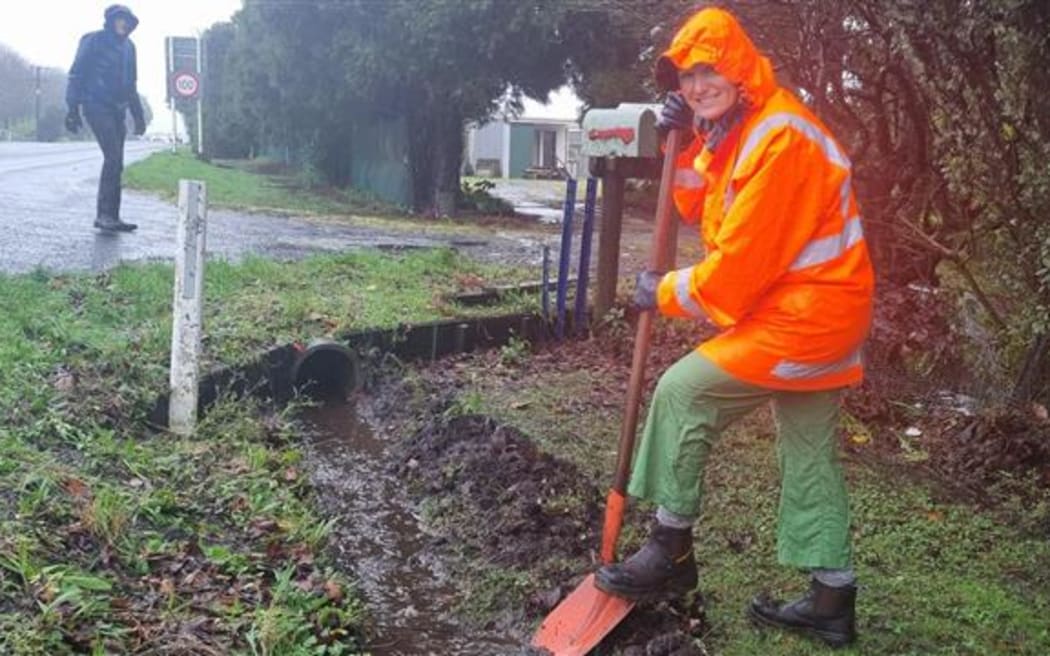 Michele D'Ath gets on the shovel at Mum Maureen's in Egmont Village to help in the aftermath of floods in Taranaki.