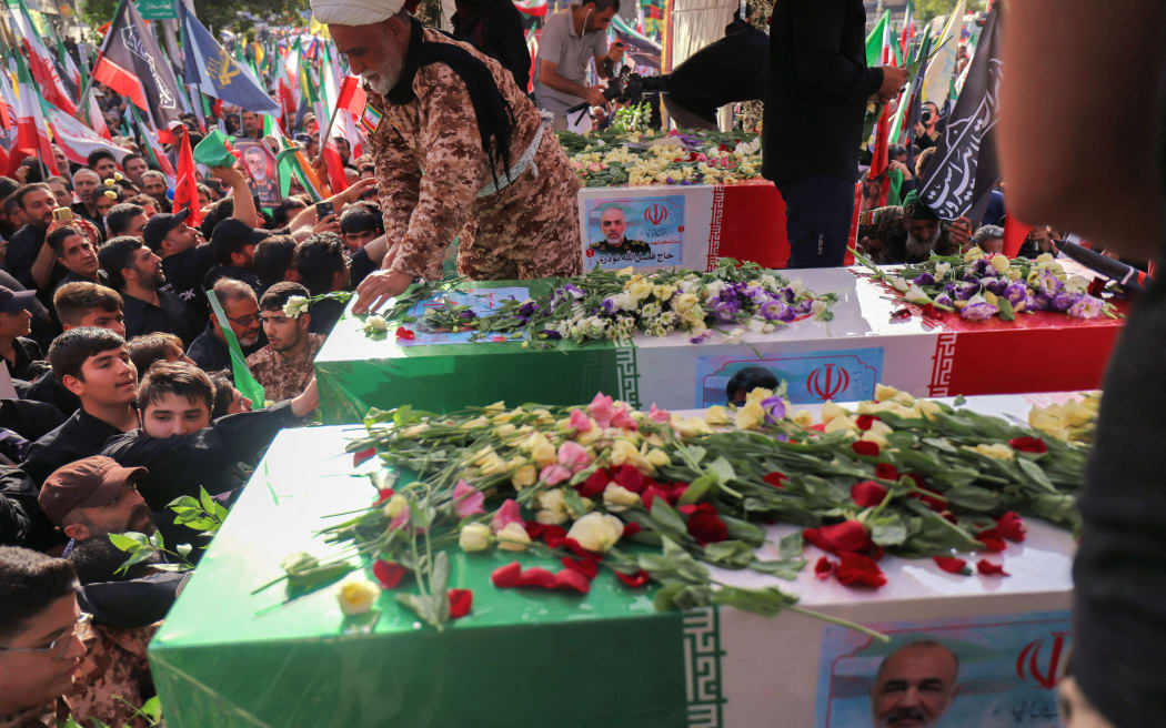 Mourners stand next to the coffin of Iranian Revolutionary Guards commander Hossein Salami (front), and other military commanders killed during Israeli strikes on the first day of the war, during their funeral procession at Enghelab (Revolution) Square in the capital Tehran on June 28, 2025. Iran began a state funeral service on June 28 for around 60 people, including its military commanders, killed in its war with Israel, after Tehran's top diplomat condemned  Donald Trump's comments on supreme leader Ali Khamenei as "unacceptable". (Photo by ATTA KENARE / AFP)