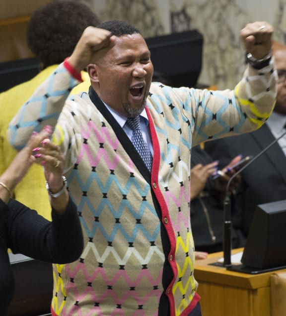 Nelson Mandela's grandson, Mandla Mandela (C) cheers after the failure of a no-confidence debate and vote