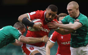 Wales' number 8 Taulupe Faletau (C) is tackled by Ireland's fly-half Jonathan Sexton (L) and Ireland's wing Keith Earls (R) during the Six Nations rugby union match between Wales and Ireland at the Principality Stadium in Cardiff, south Wales, on February 7, 2021.