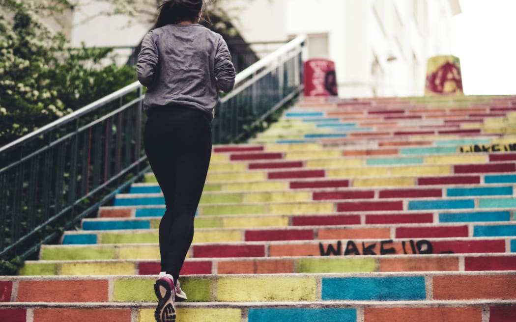 A woman running up a flight of steps.