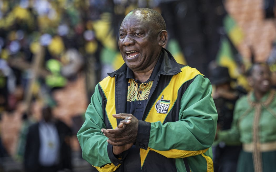 President of the ruling African National Congress (ANC) and South African President, Cyril Ramaphosa (C), sings and dances during the ANC's last rally at the FNB Stadium in Johannesburg on May 25, 2024, ahead of the South African elections scheduled for May 29, 2024. (Photo by Michele Spatari / AFP)