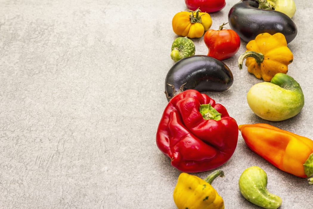 Trendy ugly organic vegetables. Assortment of fresh pepper, eggplant, cucumber, tomato, pumpkin. Cooking ugly food concept. Stone concrete background, copy space