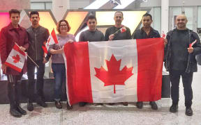 Amir Sahragard (centre) is welcomed by supporters at Toronto airport.