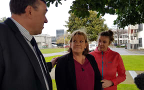 Inspector Scott Miller, Lois Tolley's aunt Yvonne Tolley, and a support person outside of court.