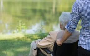 Photo of elderly man on wheelchair and his private carer