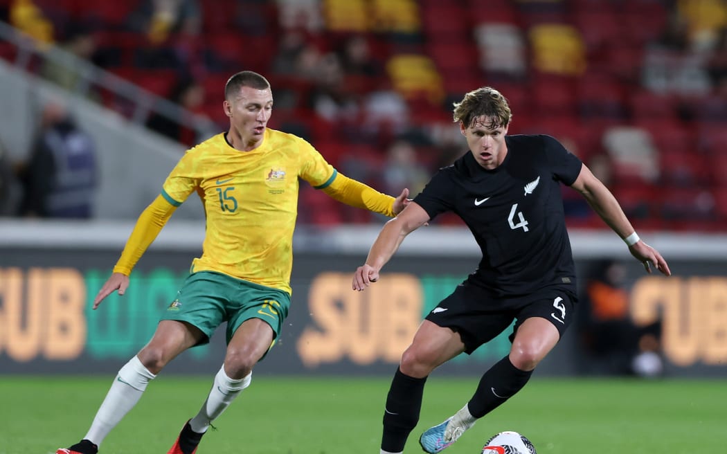 Nando Pijnaker of New Zealand is challenged by Mitchell Duke of Australia.