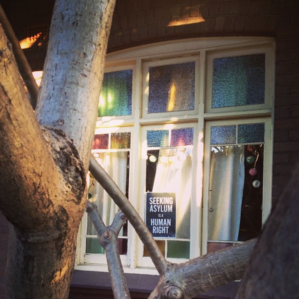 A poster in a window saying "seeking asylum is a human right"