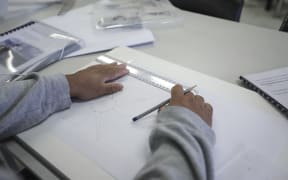 An inmate at Rimutaka Prison. The first house being built by carpentry students at the prison has been completed, a crane lifted the building over the wire so it can be transferred to a permanent site.