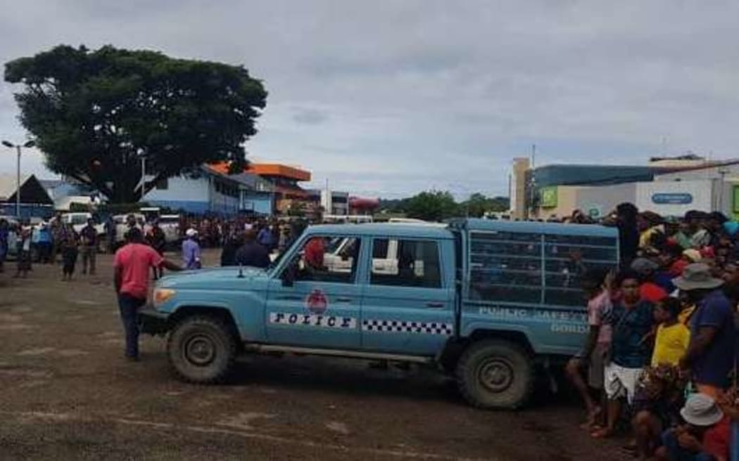 Police contain the crowd gathered at Boroka police station.