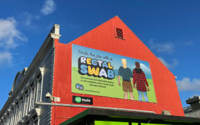 A Finish the Job with a Rectal Swab billboard on the side of a building as part of Sex Outside the City campaign.