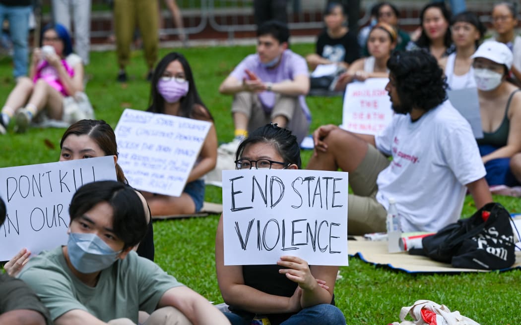 Attendees hold signs during a protest against the death penalty at Speakers' Corner in Singapore on April 3, 2022. (Photo by Roslan RAHMAN / AFP)