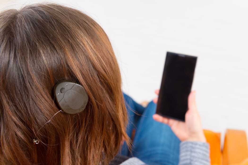 Deaf woman with cochlear implant using smartphone