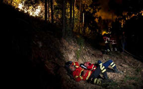 Firefighters rest during a wildfire at Penela, Coimbra, central Portugal.