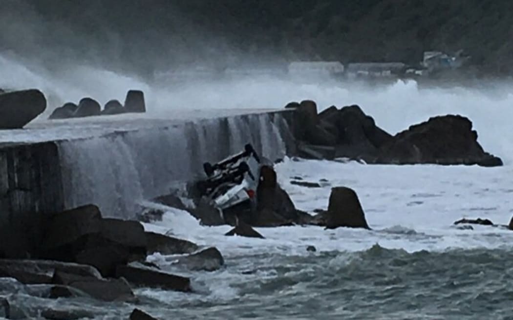 The car was parked on a seawall near Wellington Airport before it ended up stranded on a rock.