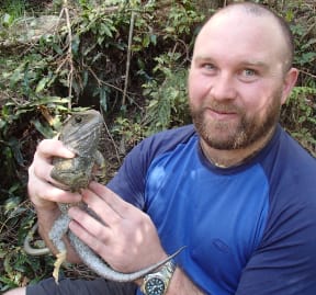 PhD student Scott Jarvie holding an adult male tuatara.
