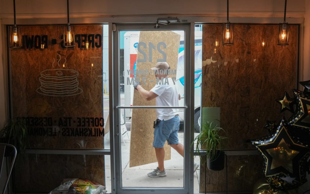 Cafe owner Illia Fesenko boards up his cafe in Tampa ahead of Hurricane Milton's expected landfall in the middle of this week on October 8, 2024 in Florida.