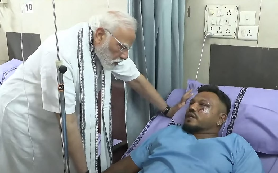 This screengrab of video footage taken and released by the Narendra Modi Youtube Channel on June 13, 2025 shows India's Prime Minister Narendra Modi (L) meeting with Vishwash Kumar Ramesh, sole survivor of the Air India flight 171 crash, at a hospital in Ahmedabad. Rescue teams with sniffer dogs combed the crash site on June 13 of the London-bound passenger jet which ploughed into a residential area of India's Ahmedabad city, killing at least 265 people on board and on the ground. (Photo by NARENDRA MODI YOUTUBE CHANNEL / AFP) / -----EDITORS NOTE --- RESTRICTED TO EDITORIAL USE - MANDATORY CREDIT "AFP PHOTO / NARENDRA MODI YOUTUBE CHANNEL " - NO MARKETING - NO ADVERTISING CAMPAIGNS - DISTRIBUTED AS A SERVICE TO CLIENTS