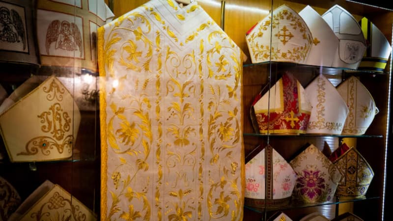 A display case of the pope's robes and some of the mitre worn.