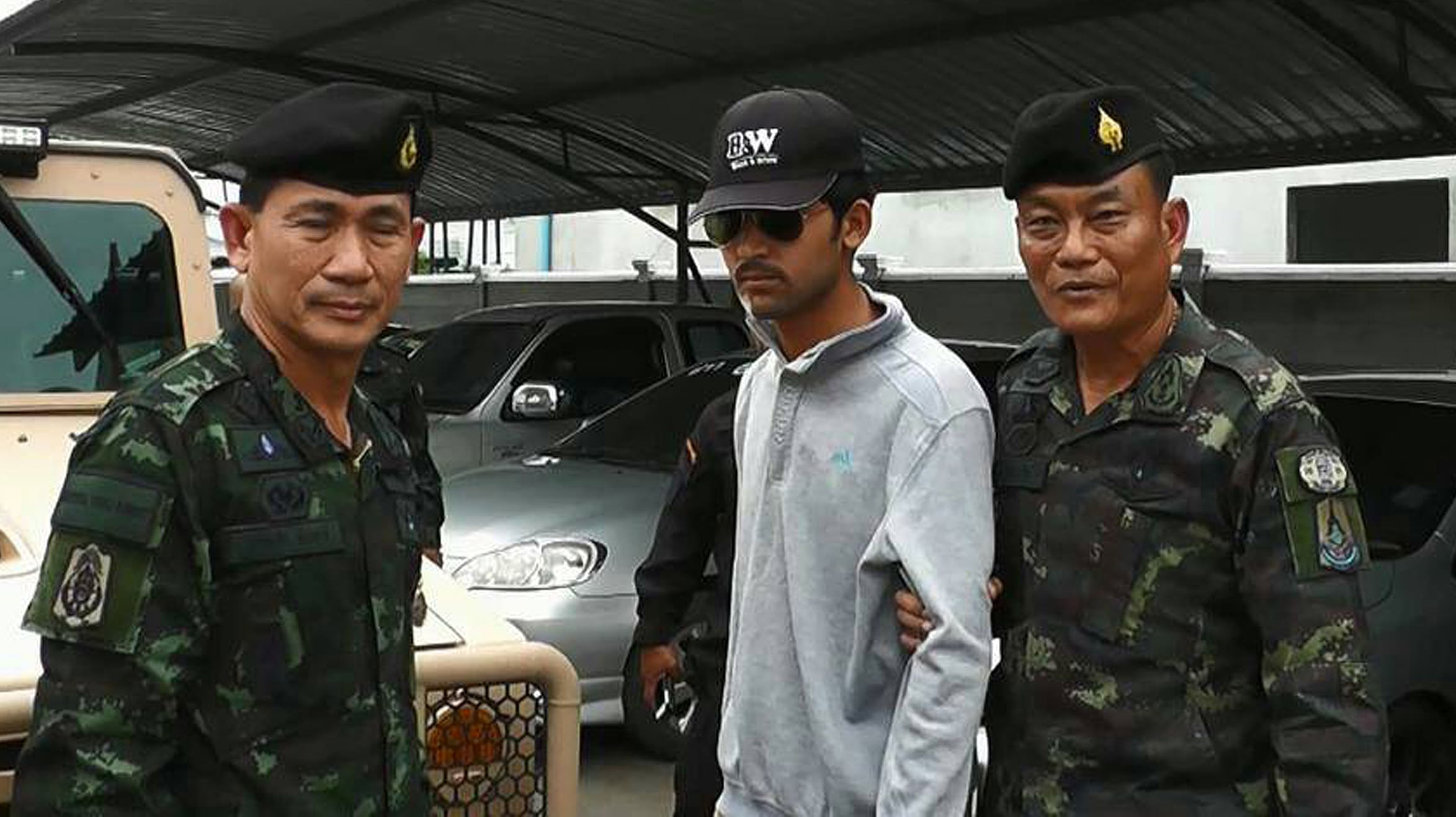 Thai police escort a suspect (centre) arrested on the Thai side of the Cambodian border on 1 September in connection with the bomb attack in Bangkok on 17 August.