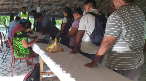 Voters check in before heading to the booths to their right at the Tangintebu Theological College Maneaba