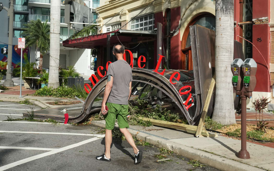 The awning of a restaurant has collapsed on the sidewalk in St. Petersburg due to Hurricane Milton on October 10, 2024 in Florida. At least four people were confirmed killed as a result of two tornadoes triggered by Hurricane Milton on the east coast of the US state of Florida, local authorities said Thursday. (Photo by Bryan R. SMITH / AFP)