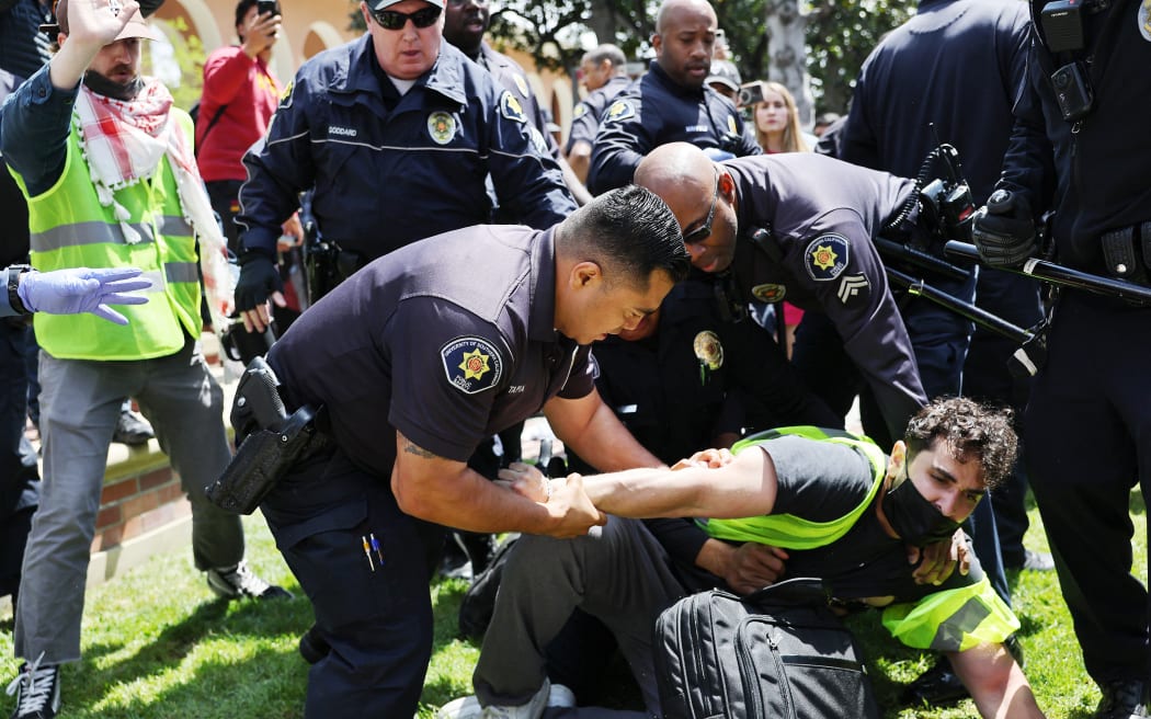 LOS ANGELES, CALIFORNIA - APRIL 24: USC public safety officers detain a pro-Palestine demonstrator during clashes after officers attempted to take down an encampment in support of Gaza at the University of Southern California on April 24, 2024 in Los Angeles, California. Pro-Palestinian encampments have sprung up at college campuses around the country recently.   Mario Tama/Getty Images/AFP (Photo by MARIO TAMA / GETTY IMAGES NORTH AMERICA / Getty Images via AFP)