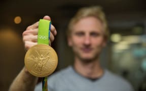 Hamish Bond holding his Olympic gold medal from the Rio 2016 Olympics